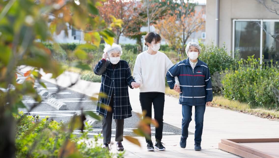 入居者とケアマネジャーが散歩している